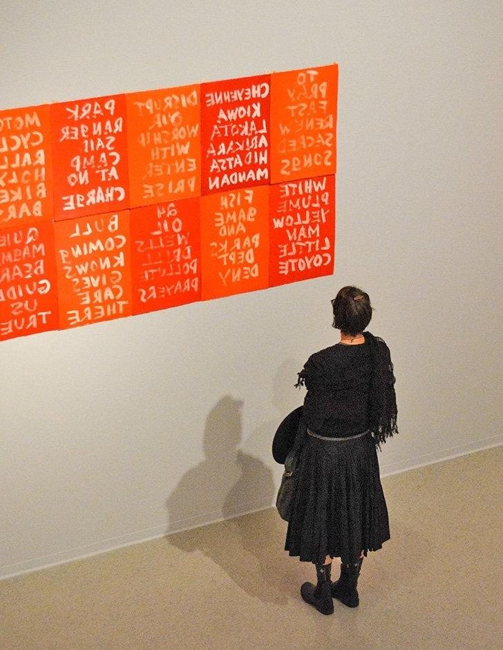 a gallery visitor looks at the art on the walls