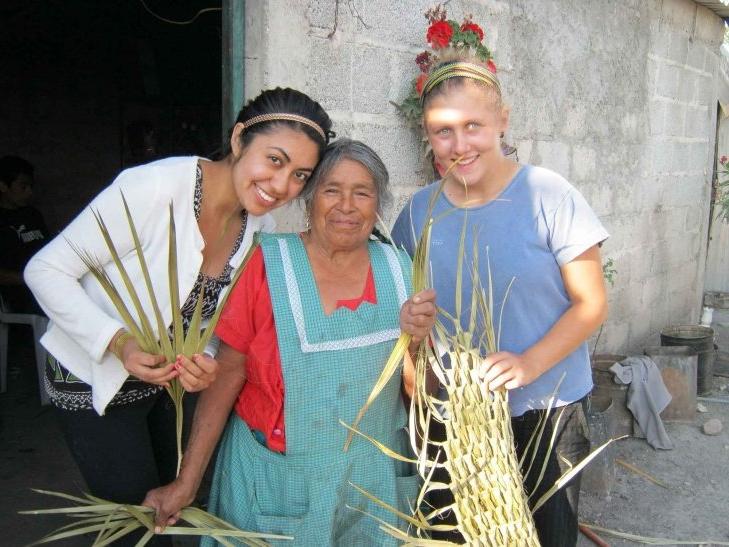 two pitzer students hold up palm art 