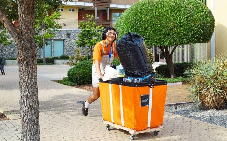 a student worker helps move items to a dorm room on move in day